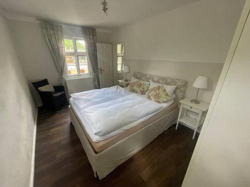 1 dormitorio con cama blanca y ventana en Ferienwohnung im Landhaus Labes (Stechlinsee) en Neuglobsow
