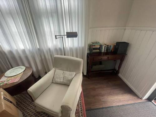 a living room with a white chair and a desk at Ferienwohnung im Landhaus Labes (Stechlinsee) in Neuglobsow