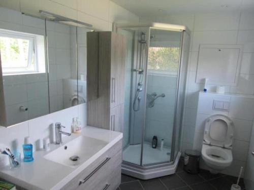 uma casa de banho com um chuveiro, um lavatório e um WC. em Airbnb and Booking at Postvegen 95 em Vigra