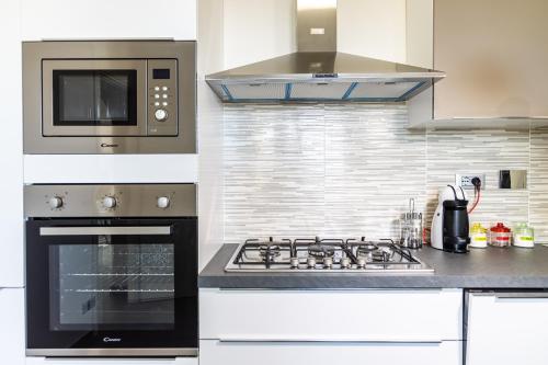 uma cozinha com uma placa de fogão e um micro-ondas em Sanremo Dream - Casa Camilla em Sanremo