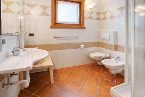 ein Badezimmer mit zwei Waschbecken und einem WC in der Unterkunft Baita dei ski app 1 in Livigno