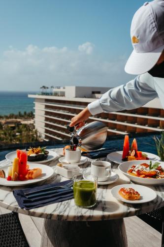 a table with plates of food on a balcony at Secrets Moxché Playa del Carmen - Adults Only - All Inclusive in Playa del Carmen