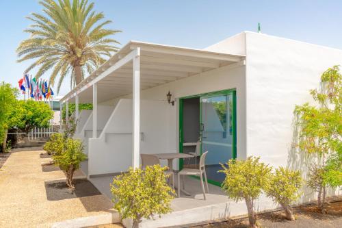 a small white house with a table and chairs at Hyde Park Lane in Puerto del Carmen