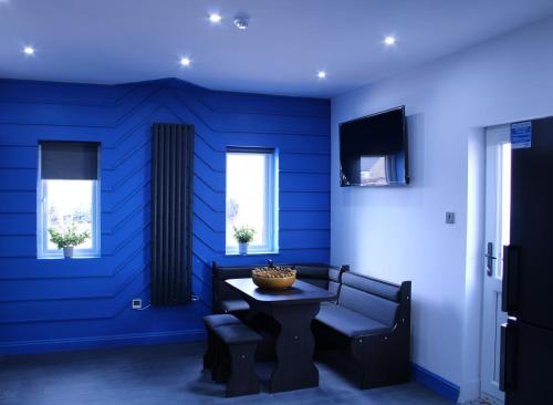 Habitación azul con mesa y silla en Private Room in Peterborough with own Kitchenette, en Peterborough