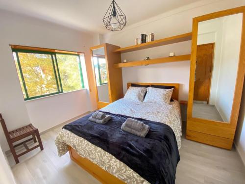 una camera da letto con un letto e una grande finestra di Appartement luxueux - Vue magnifique, piscine, balcon - Parking a Foz do Arelho
