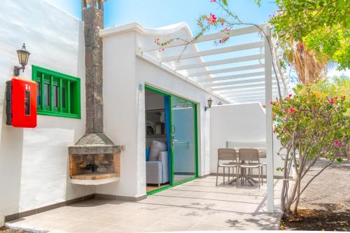 a white house with a fireplace and a patio at Hyde Park Lane in Puerto del Carmen