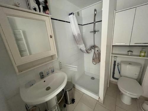 een witte badkamer met een wastafel en een toilet bij Villa Magali - Appartement climatisé T3 Duplex - Grau-du-Roi - Hypercentre 20 m de la plage in Le Grau-du-Roi