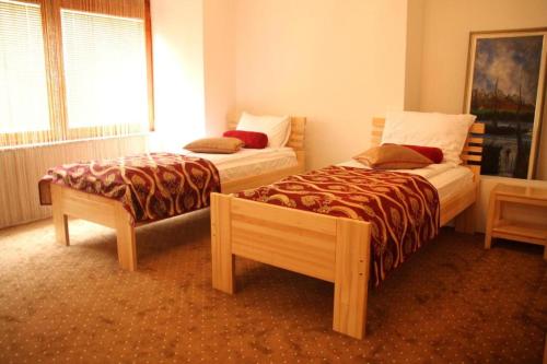 a room with two beds and a bench in it at Hotel Berr in Sarajevo