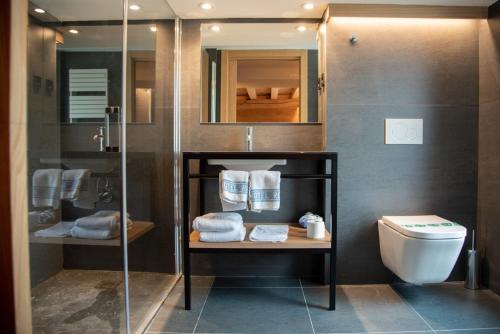 a bathroom with a shower and a toilet with towels at Hotel Roya in Espot