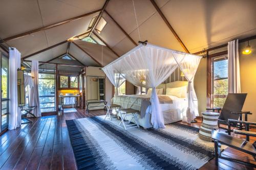 - une chambre avec un lit à baldaquin dans une tente dans l'établissement The Mushara Outpost, à Namutoni