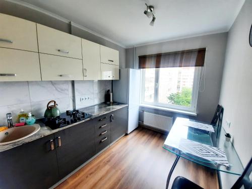 a kitchen with a table and a sink and a window at Light Apartment in Rīga