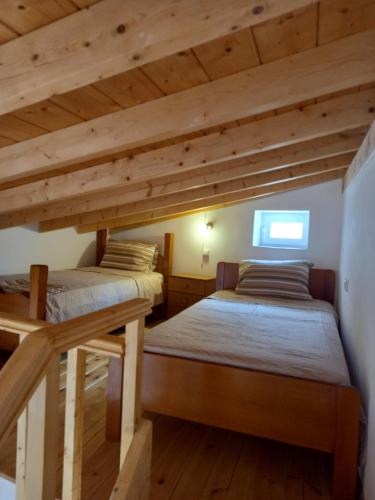 two beds in a room with wooden ceilings at APANEMA HOUSE in Egina