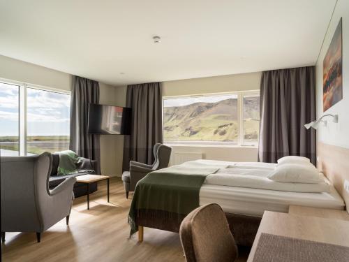 a hotel room with a bed and a desk and chairs at Hotel Katla by Keahotels in Vík