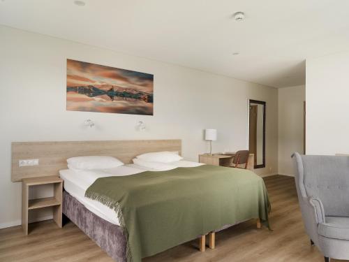 - une chambre avec un lit et une chaise dans l'établissement Hotel Katla by Keahotels, à Vík