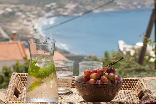 a table with a bowl of grapes and a drink at Mani Tower by Olive Villa Rentals in Oítilon