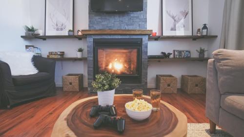a living room with a coffee table with a fireplace at Chalet Le Convivial Tremblant in Lac-Superieur