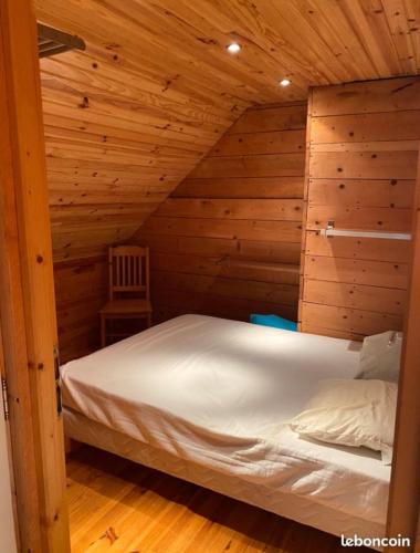 a bedroom with a bed in a wooden cabin at Maison Auvergne volcan Puy Mary Claux Giraldès GR400 in Le Claux