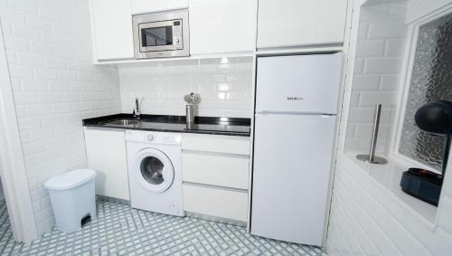 cocina blanca con fregadero y lavadora en APARTAMENTOS RAMAR 1, en Pravia