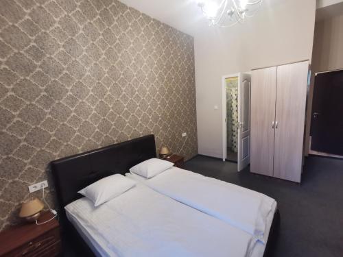 a bedroom with a bed and a wall at Hotel Kārklu Muiža in Jelgava