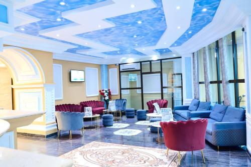 a lobby with blue and red furniture and windows at Hôtel Sindz Palace in Yaoundé