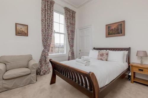 a bedroom with a bed and a couch and a window at St James Quarter 2 Bed Apartment in Edinburgh
