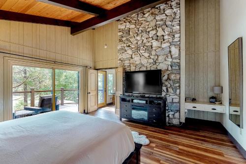 um quarto com uma cama grande e uma parede de pedra em Twets Lakefront em Bass Lake