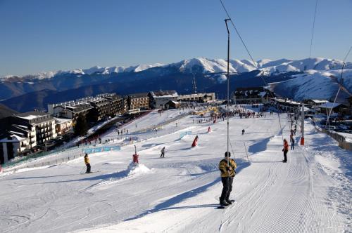 a group of people skiing down a snow covered slope at Résidence Odalys Soleil d'Aure in Saint-Lary-Soulan