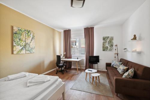um quarto de hotel com uma cama, um sofá e uma mesa em Cozy flat near Ku'damm with free parking em Berlim