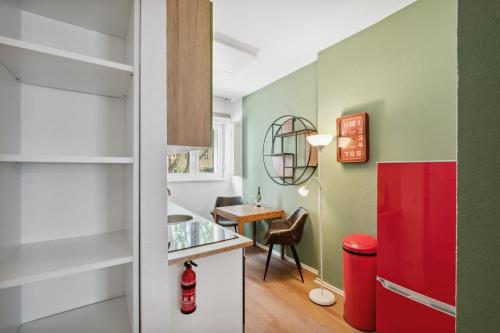 uma cozinha com um frigorífico vermelho e uma mesa em Cozy flat near Ku'damm with free parking em Berlim