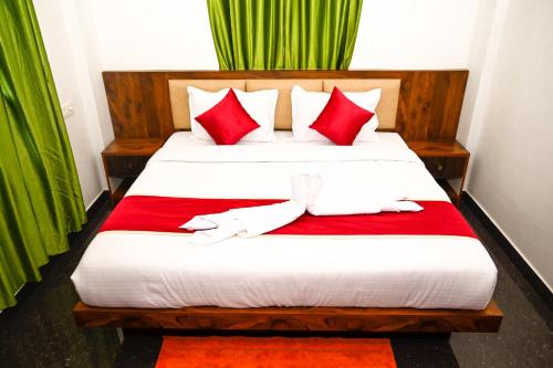 a bedroom with a large bed with red pillows at Besrauma Vythiri in Vythiri