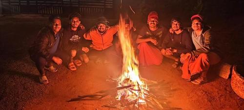 a group of people sitting around a fire at Besrauma Vythiri in Vythiri