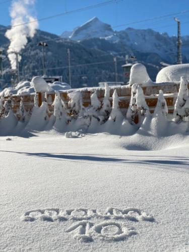 a word written in the snow next to a fence at moun10 urlaubswohnen in Garmisch-Partenkirchen