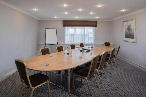 a conference room with a large wooden table and chairs at The Park Royal Hotel & Spa in Warrington