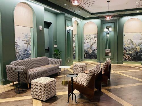 a waiting room with couches and chairs and paintings at Virgin Hotels New Orleans in New Orleans
