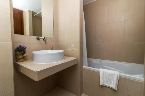 een badkamer met een wastafel en een ligbad bij Apartment Villa das Lagoas - By Dalma Portuguesa in Galé