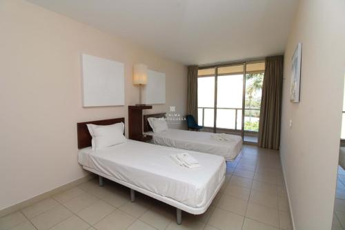een hotelkamer met twee bedden en een raam bij Apartment Villa das Lagoas - By Dalma Portuguesa in Galé