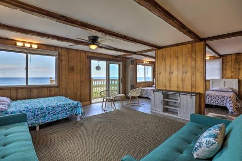 a living room with a couch and a bed and windows at Charming Oceanfront Home on Salisbury Beach in Salisbury