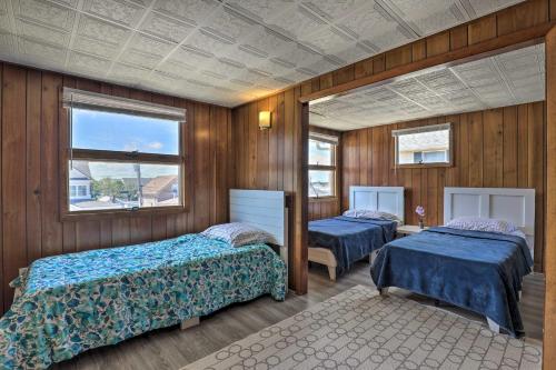 two beds in a room with wooden walls at Charming Oceanfront Home on Salisbury Beach in Salisbury