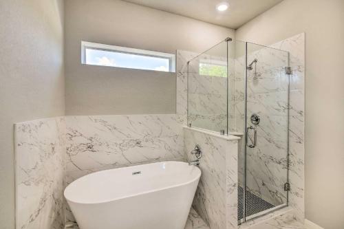 a bathroom with a shower and a white tub at 7 Mi to Ocean Family-Friendly Texas City Home! in Texas City