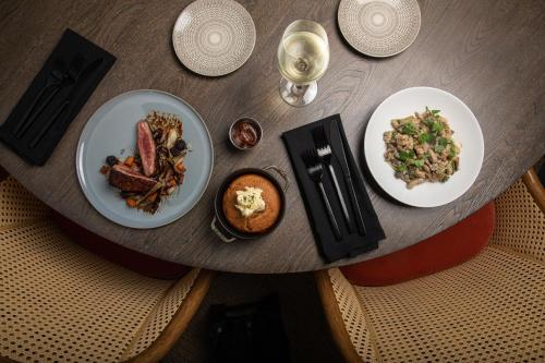 a wooden table with two plates of food on it at Virgin Hotels New Orleans in New Orleans