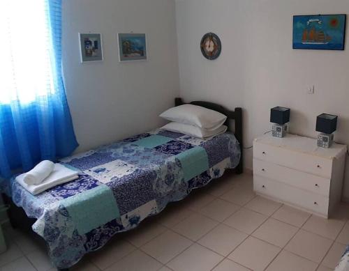 a small bedroom with a bed and a dresser at KLEO HOUSE Kalives Polygyros Halkidiki in Kalives Poligirou