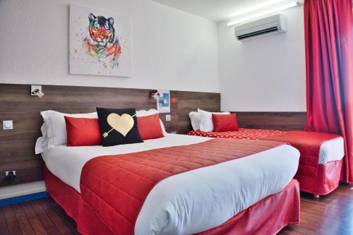 two beds in a room with red and white at Cit'Hotel des 2 Golfs in Port Leucate