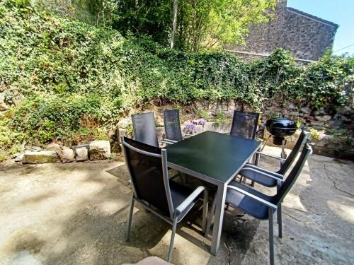 a table with four chairs and a grill at Les Gites d'Olloy - Le Beauséjour in Olloy-sur-Viroin