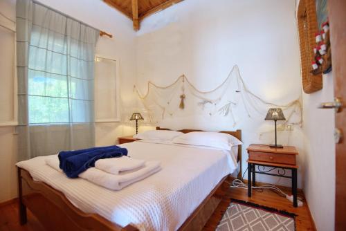 1 dormitorio con 1 cama con sábanas blancas y ventana en Seahorse cottage, en Mourterón