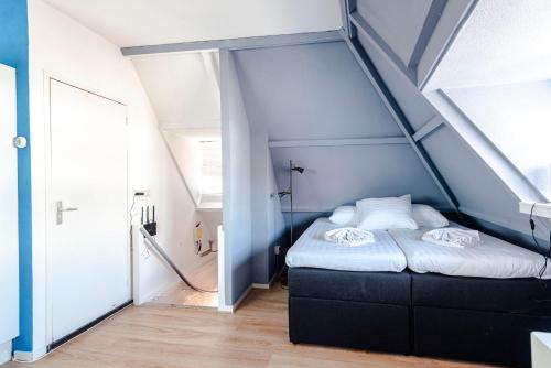 a small bedroom with a bed in a attic at Bluys Apartment in Zandvoort