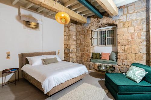 a bedroom with a bed and a couch and a chair at Jozefin in ‘Akko