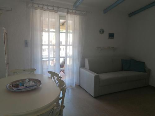 uma sala de estar com uma mesa e um sofá em La Casetta Cannigione em Cannigione