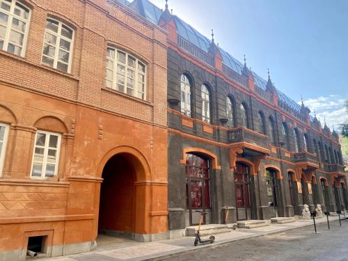 a large brick building with a person walking in front of it at Heart of Yerevan - City Center Luxury Apartments in Yerevan