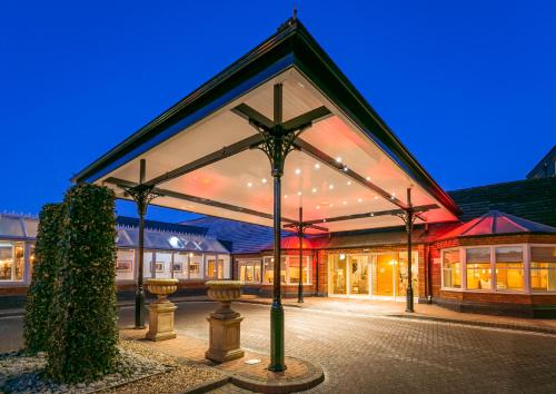 a large building with a large glass facade at night at The Park Royal Hotel & Spa in Warrington