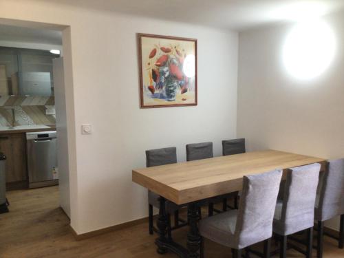 uma cozinha e sala de jantar com uma mesa de madeira e cadeiras em Escapade côte d'Azur em Saint-Aygulf